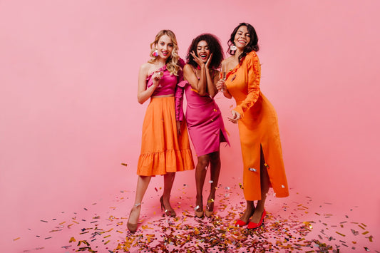 Joyful women celebrating and laughing amid a shower of colorful confetti, radiating happiness and positive energy in a lively and vibrant atmosphere.